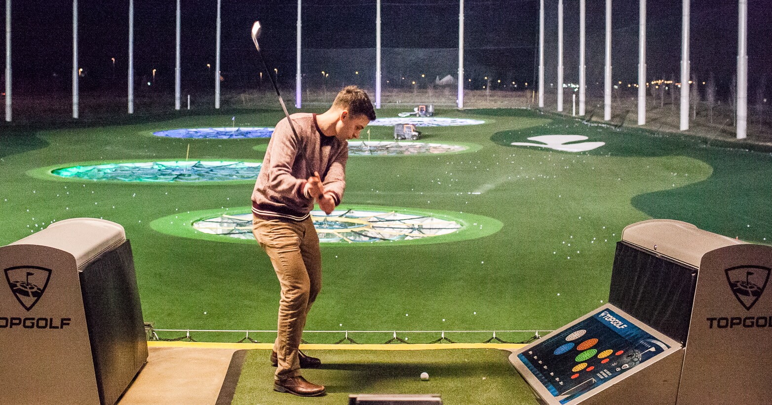 Man hitting a golf ball at Top Golf